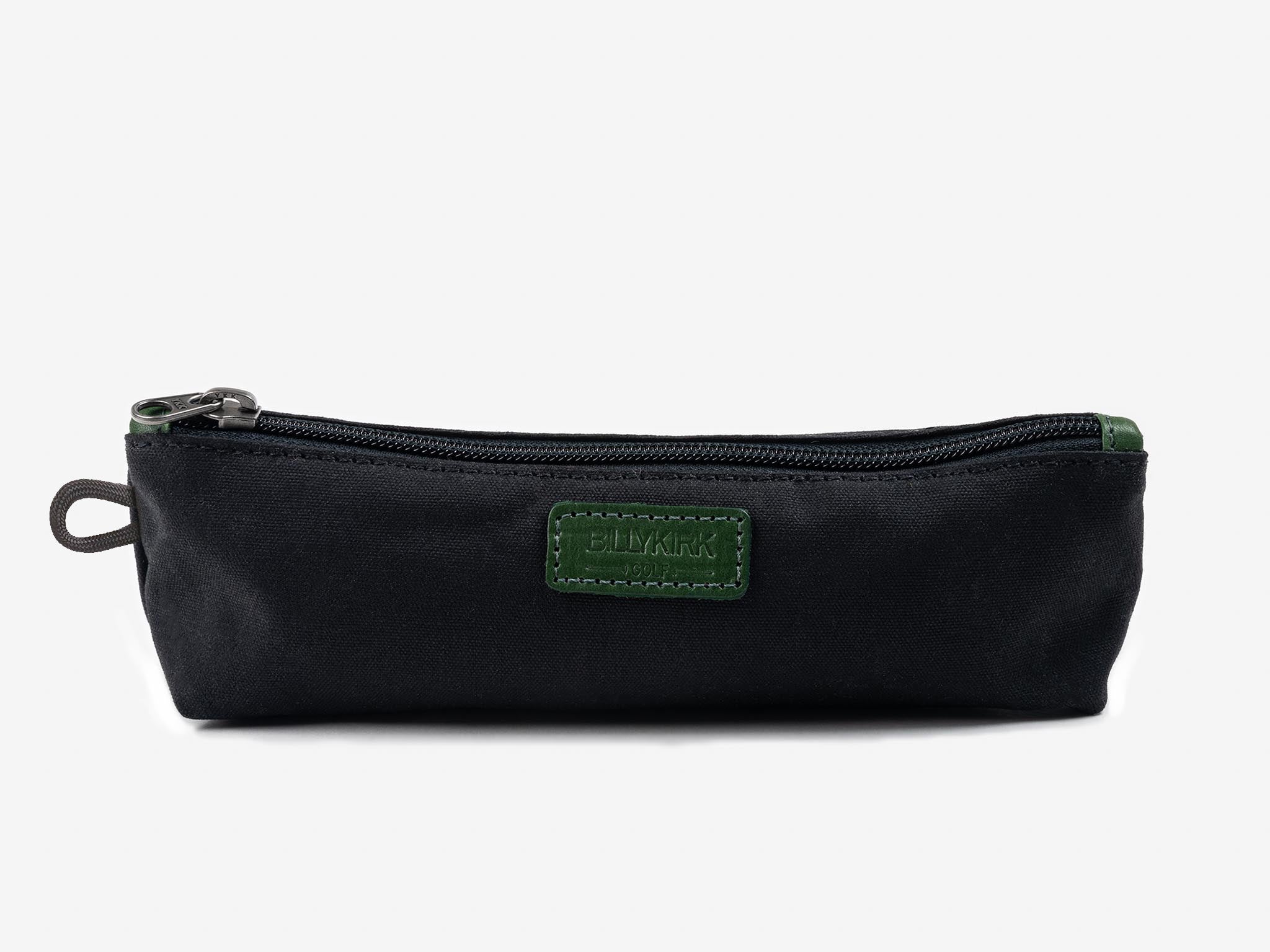A black fabric pencil case with a green patch and a zipper closure, photographed against a plain white background.