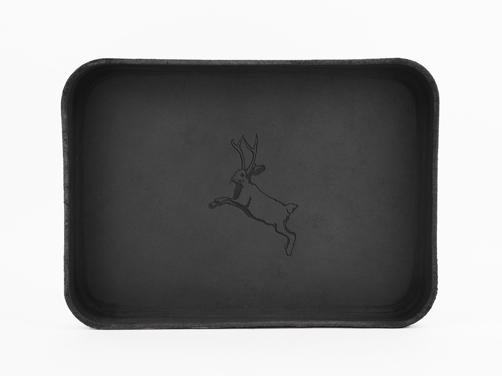 A rectangular black tray with rounded corners features an outline illustration of a leaping jackalope, a mythical animal with antlers, in the center. The background is plain white.
