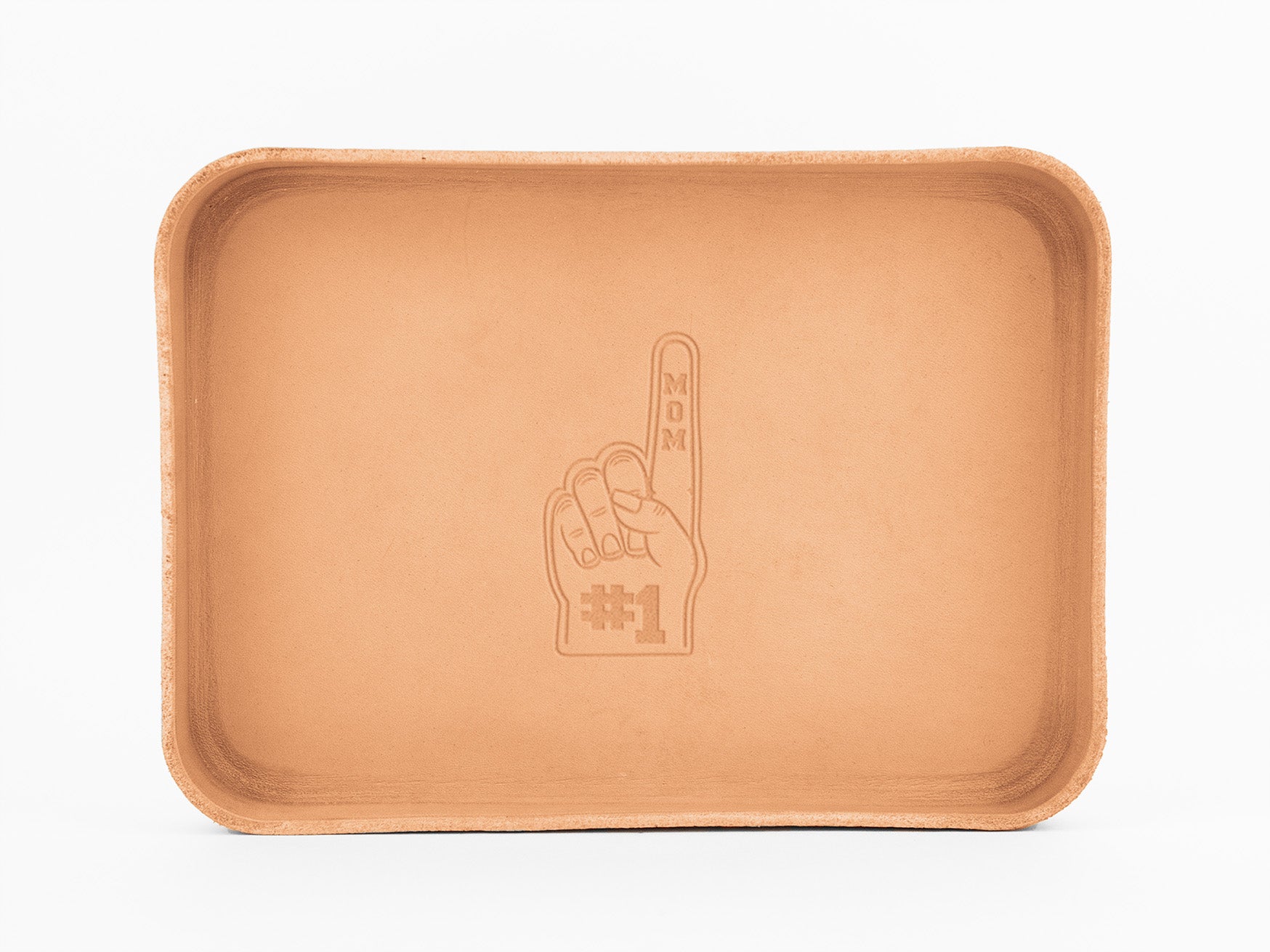 A rectangular tan leather tray with rounded edges, featuring an embossed image of a foam finger saying #1 MOM in the center. The tray is photographed against a white background.