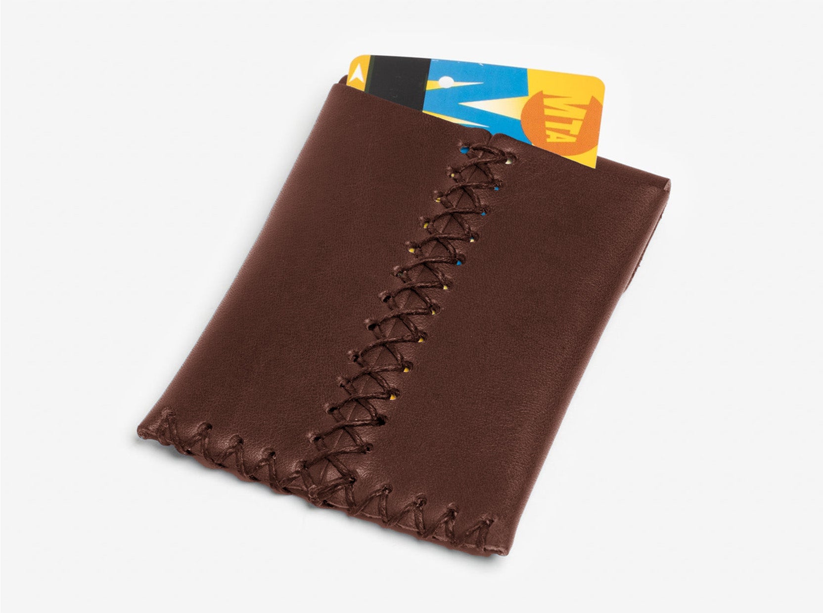 A brown leather card holder with decorative stitching, holding a partially visible yellow and blue MTA card.