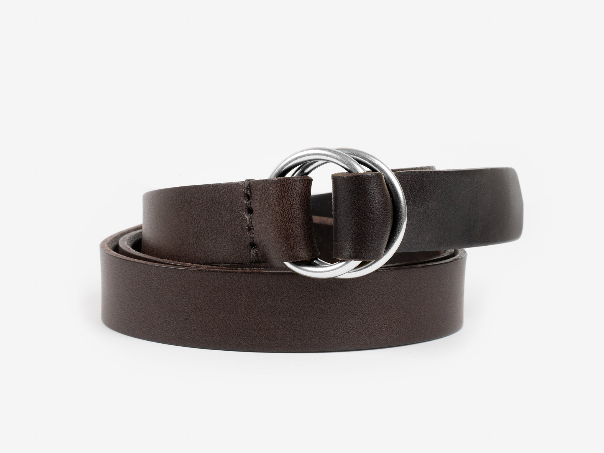 A brown leather belt with double silver metal rings as the buckle, coiled neatly on a plain white background.