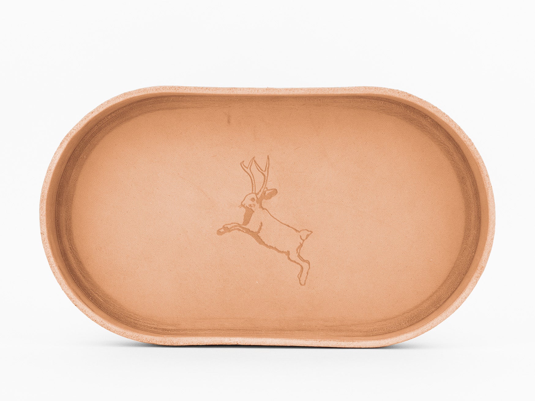 An oval-shaped, natural colored  tray with a simple engraving of a jackalope—a rabbit with antlers—centered on the tray.