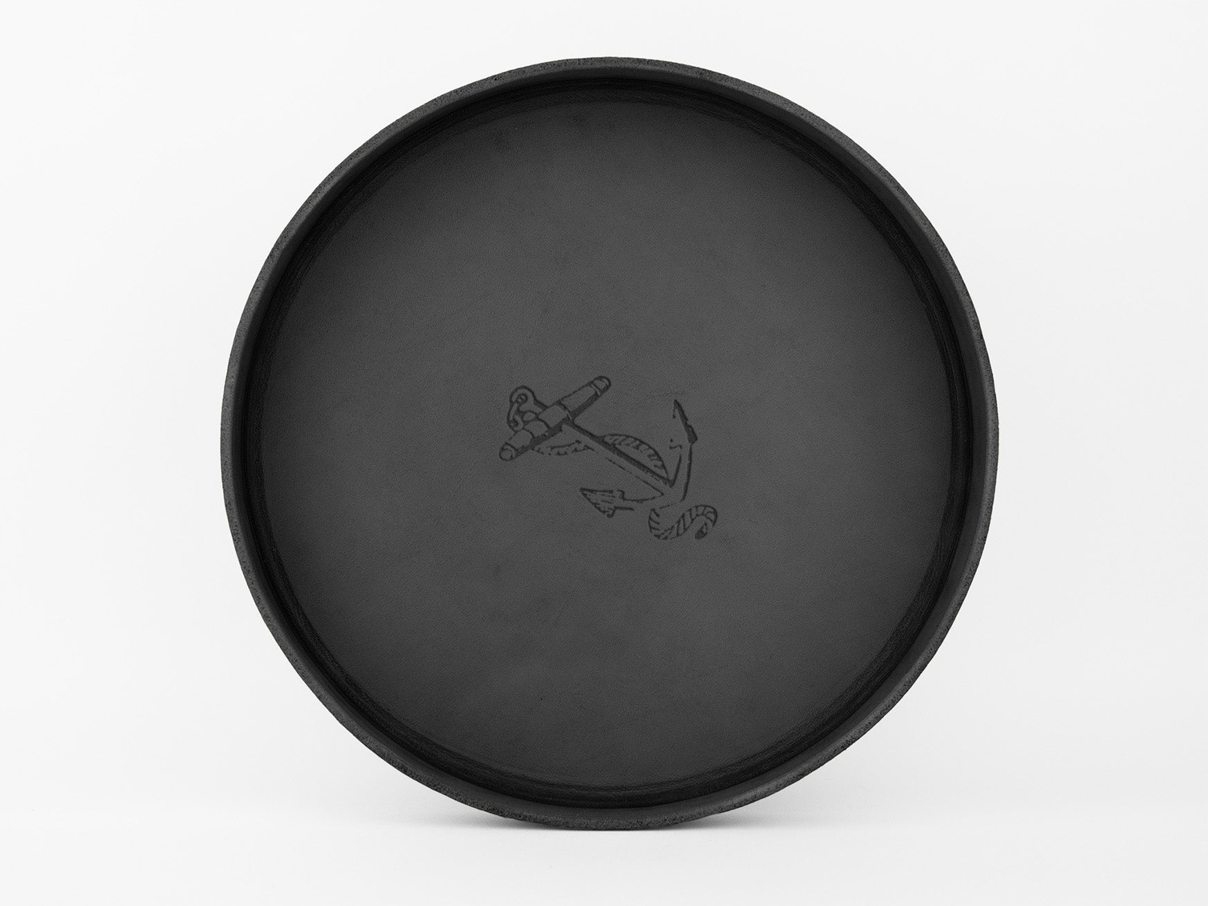A round, black tray with a simple anchor and rope illustration in the center, set against a plain white background.