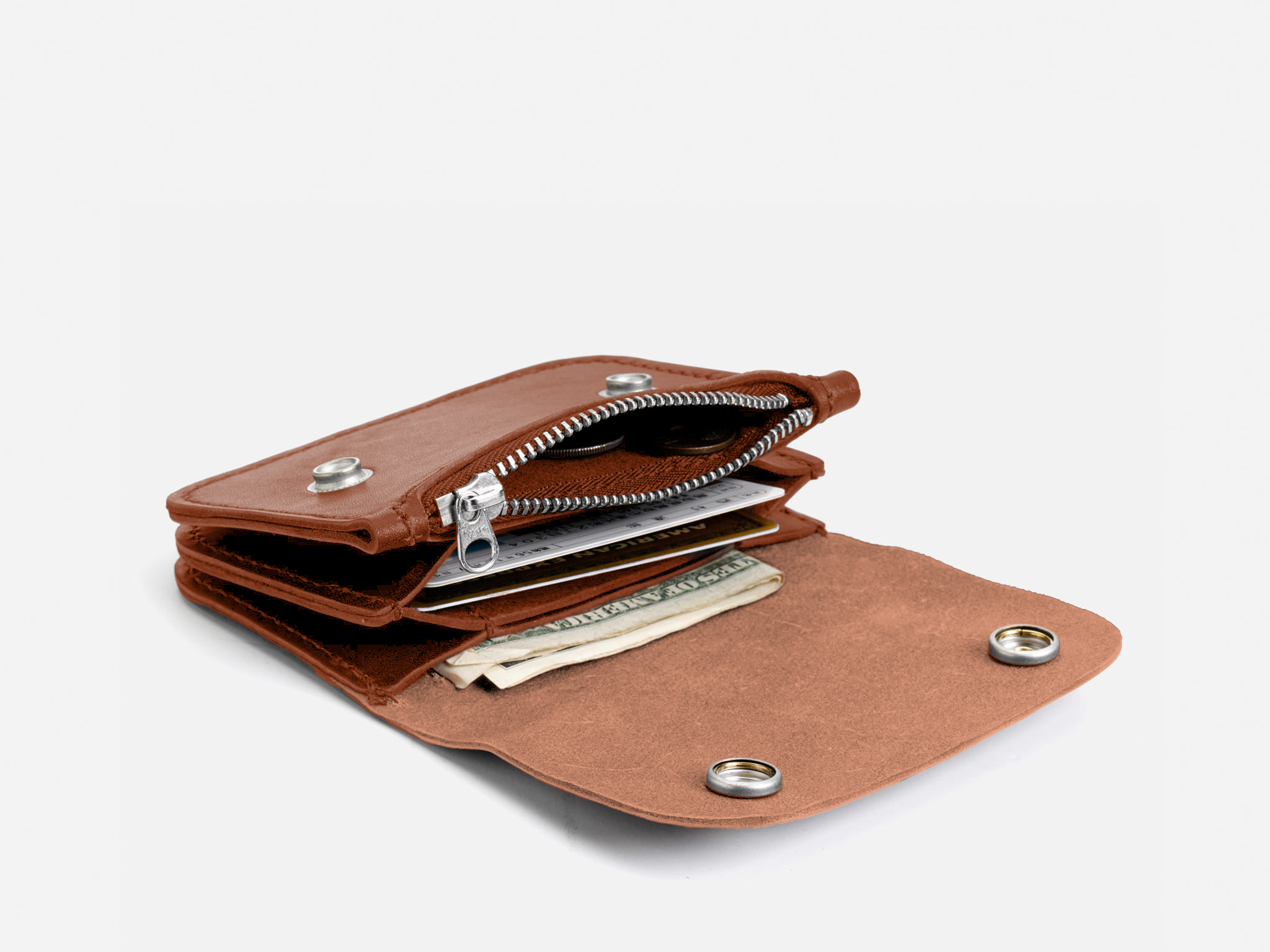 A brown leather wallet with snap buttons is open, revealing cash, cards, and a zippered coin pocket against a plain white background.