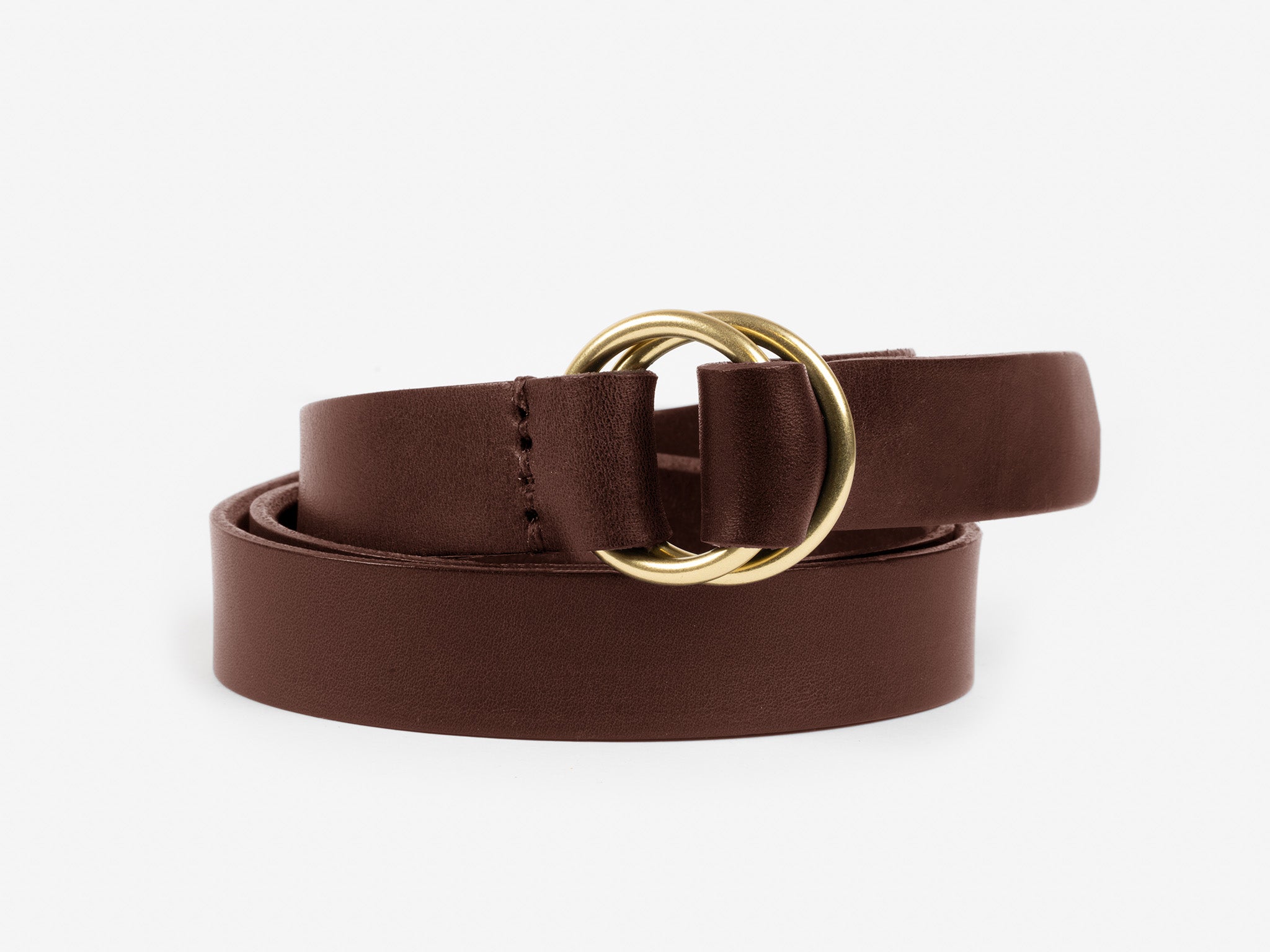 A brown leather belt with dual gold circular rings as the buckle, coiled with one end threaded through the rings, displayed on a plain white background.