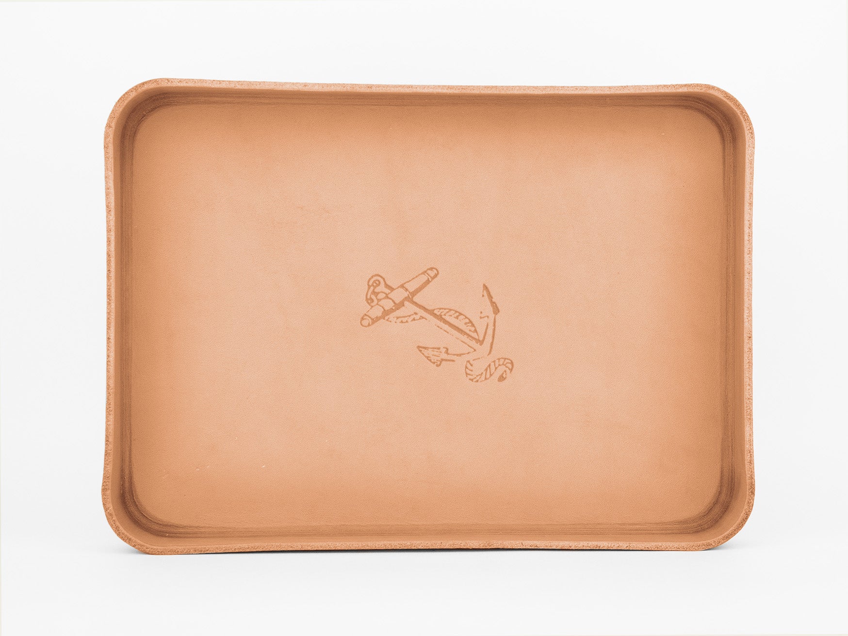 A rectangular tan leather tray with raised edges and an embossed anchor design in the center, set against a white background.