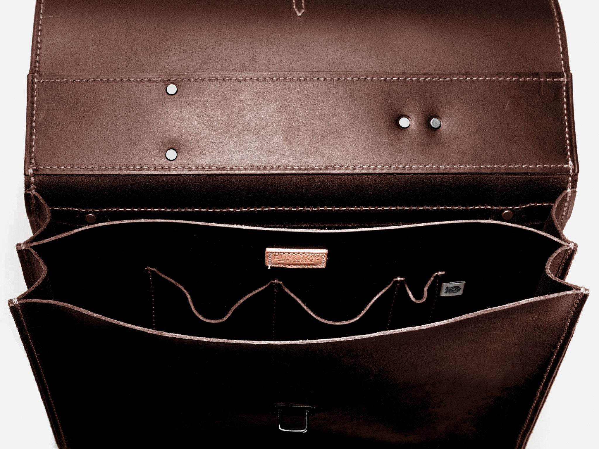 An open brown leather briefcase is shown from above, revealing multiple interior compartments and pockets. The inside lining is smooth and has stitched details and some metal studs visible.