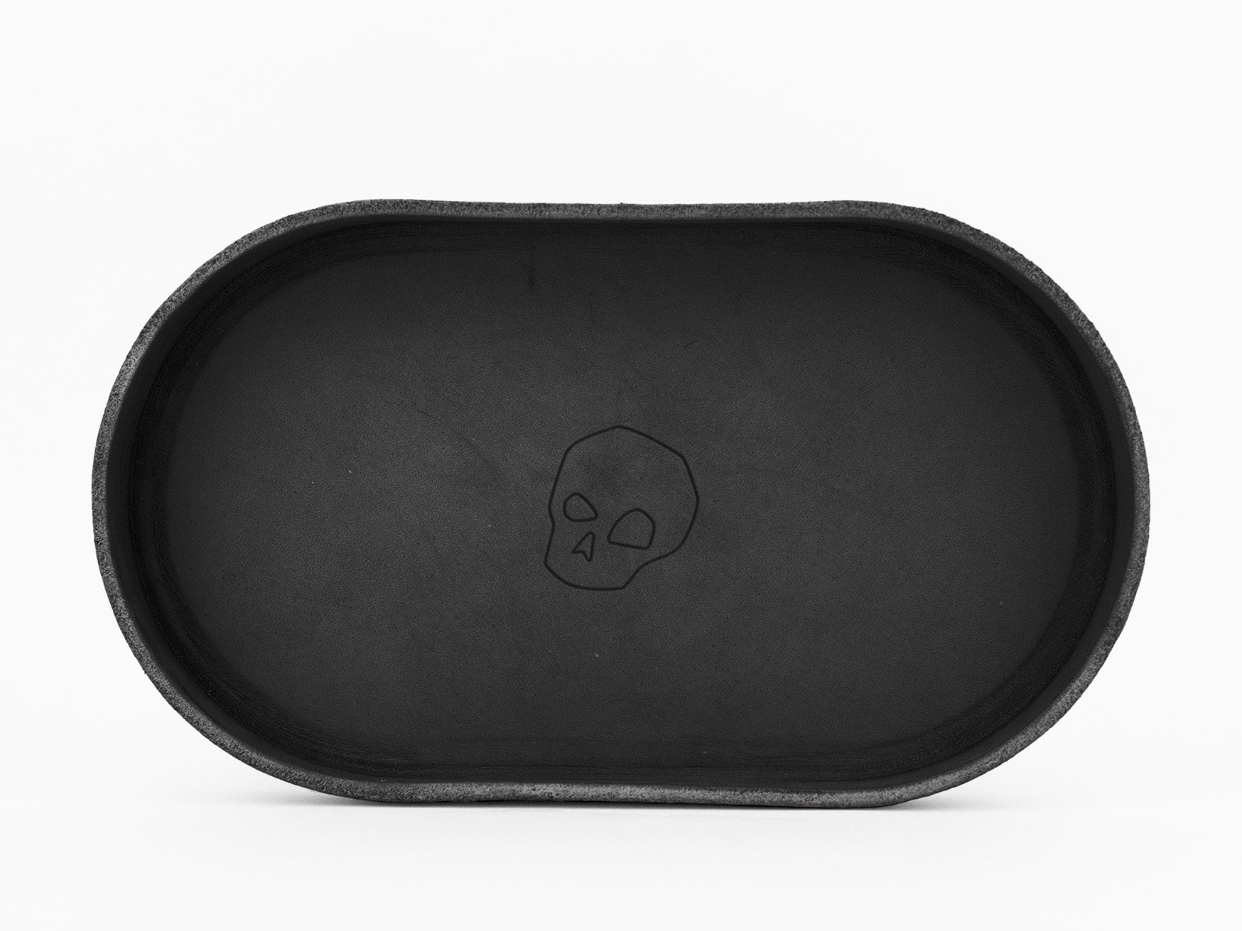 A black oval tray with a simple outline drawing of a skull in the center, placed on a white background.