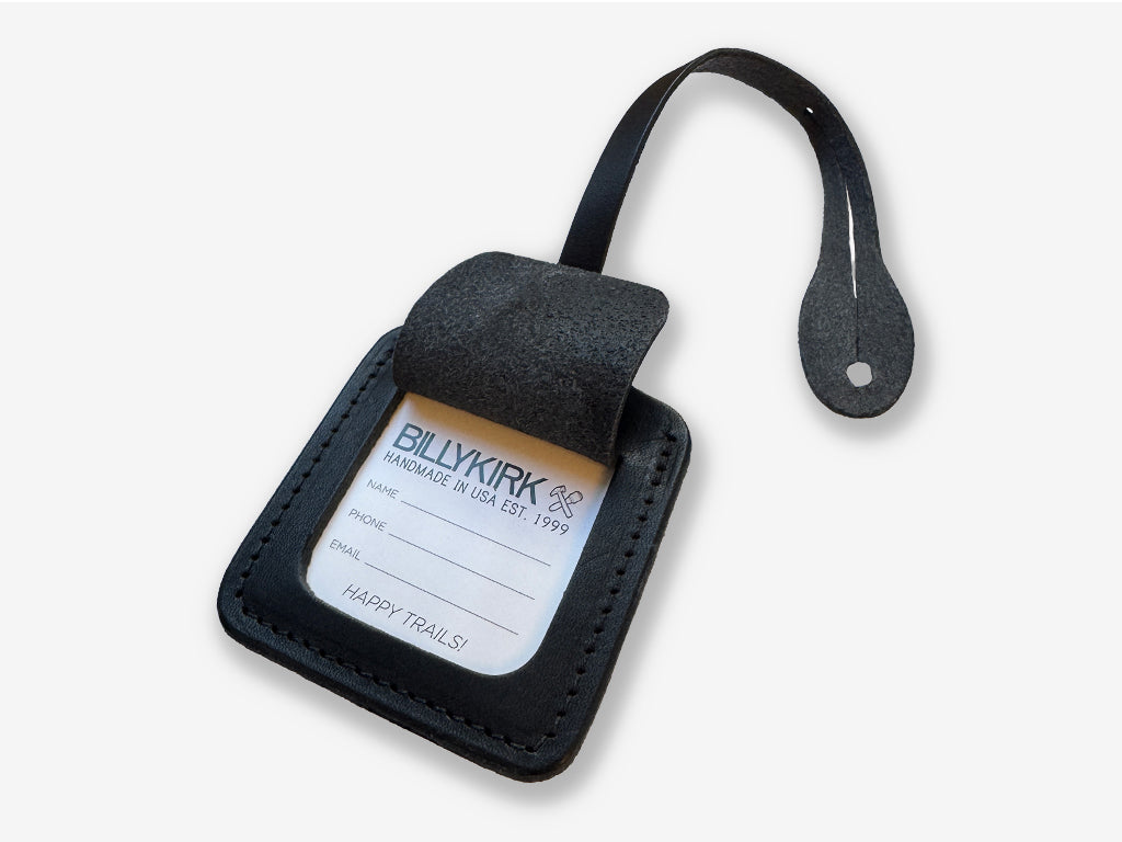 Black leather luggage tag with a label on a white background