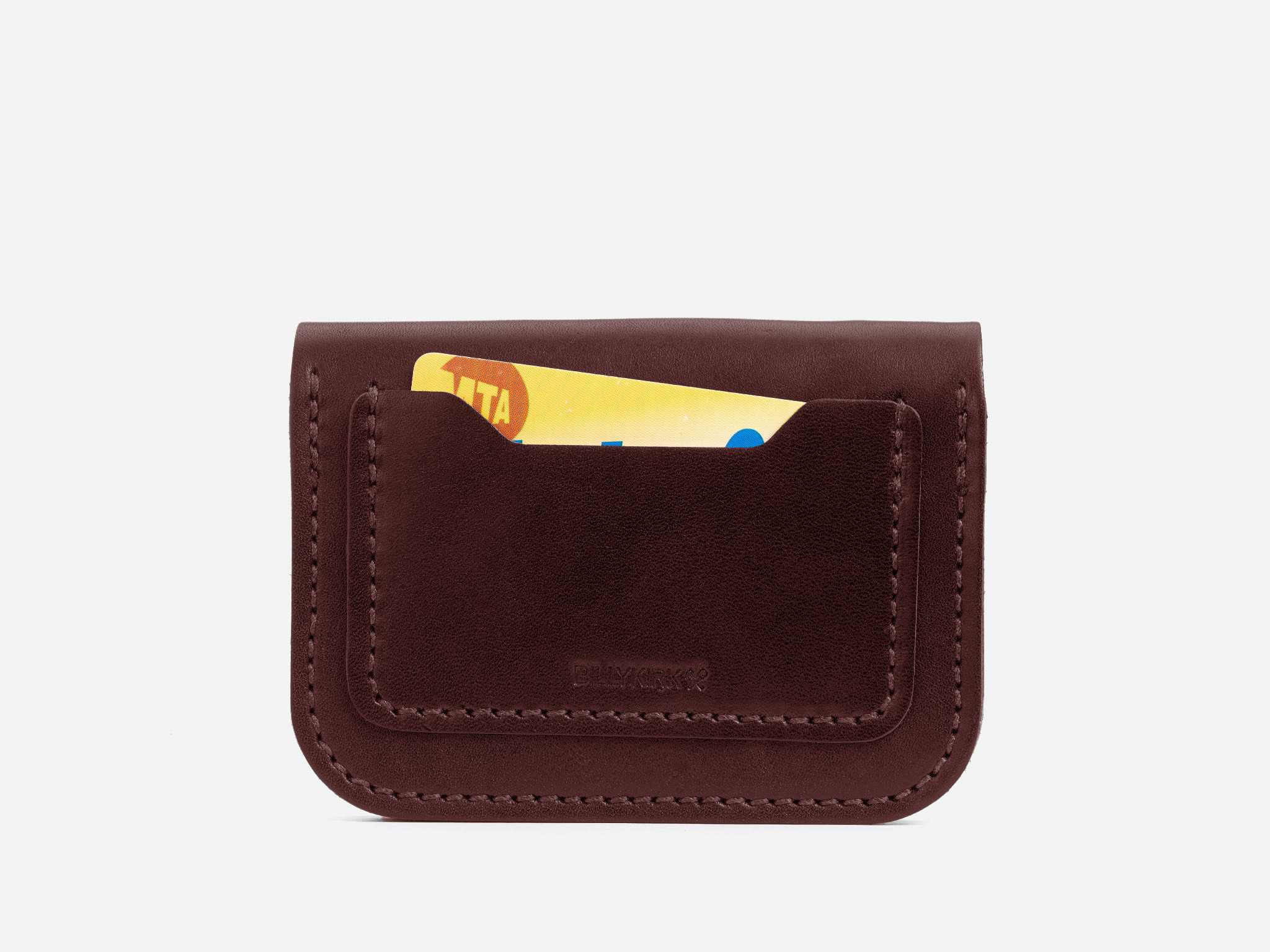 A brown leather card holder with visible stitching, holding a partially visible yellow and red card, displayed against a white background.