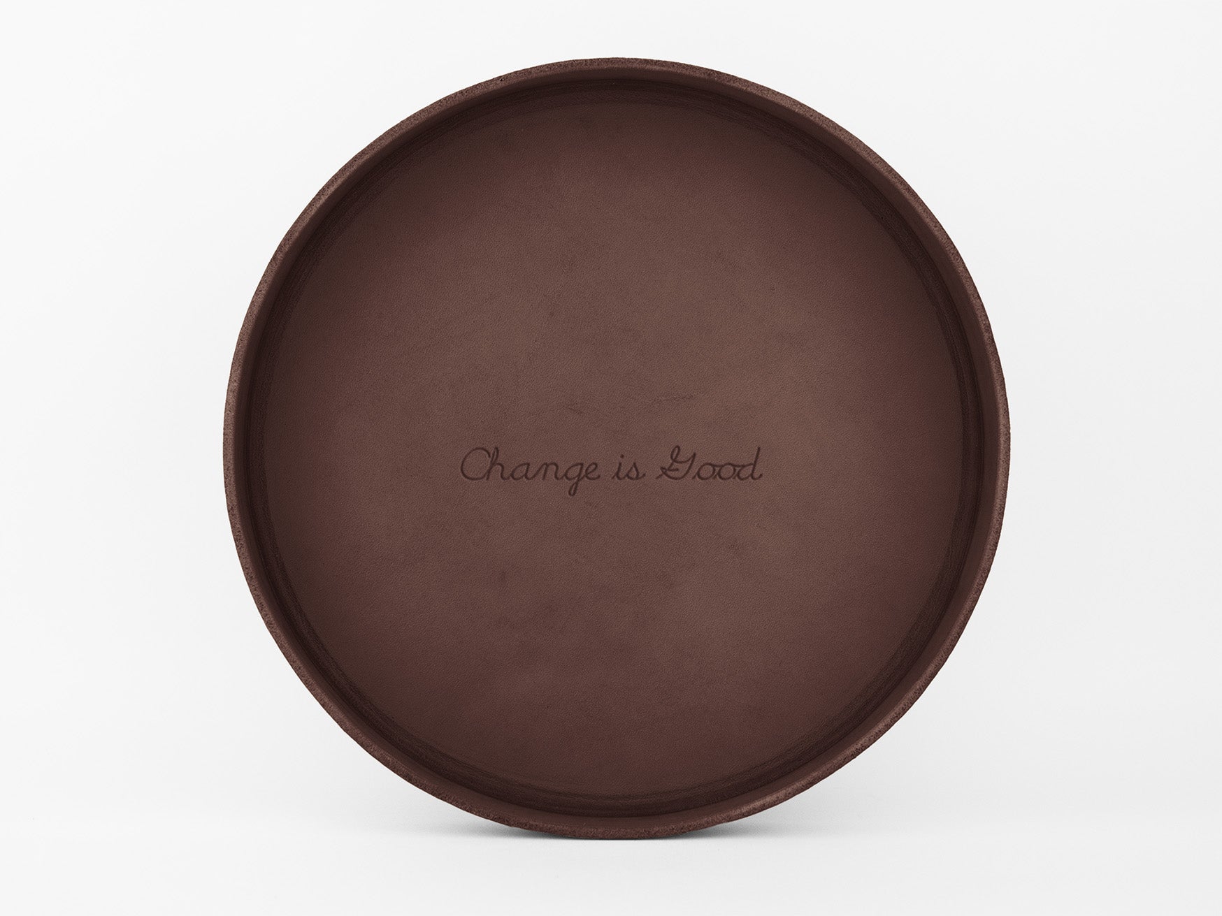 A round, brown tray with the phrase Change is Good engraved in the center, set against a plain white background.