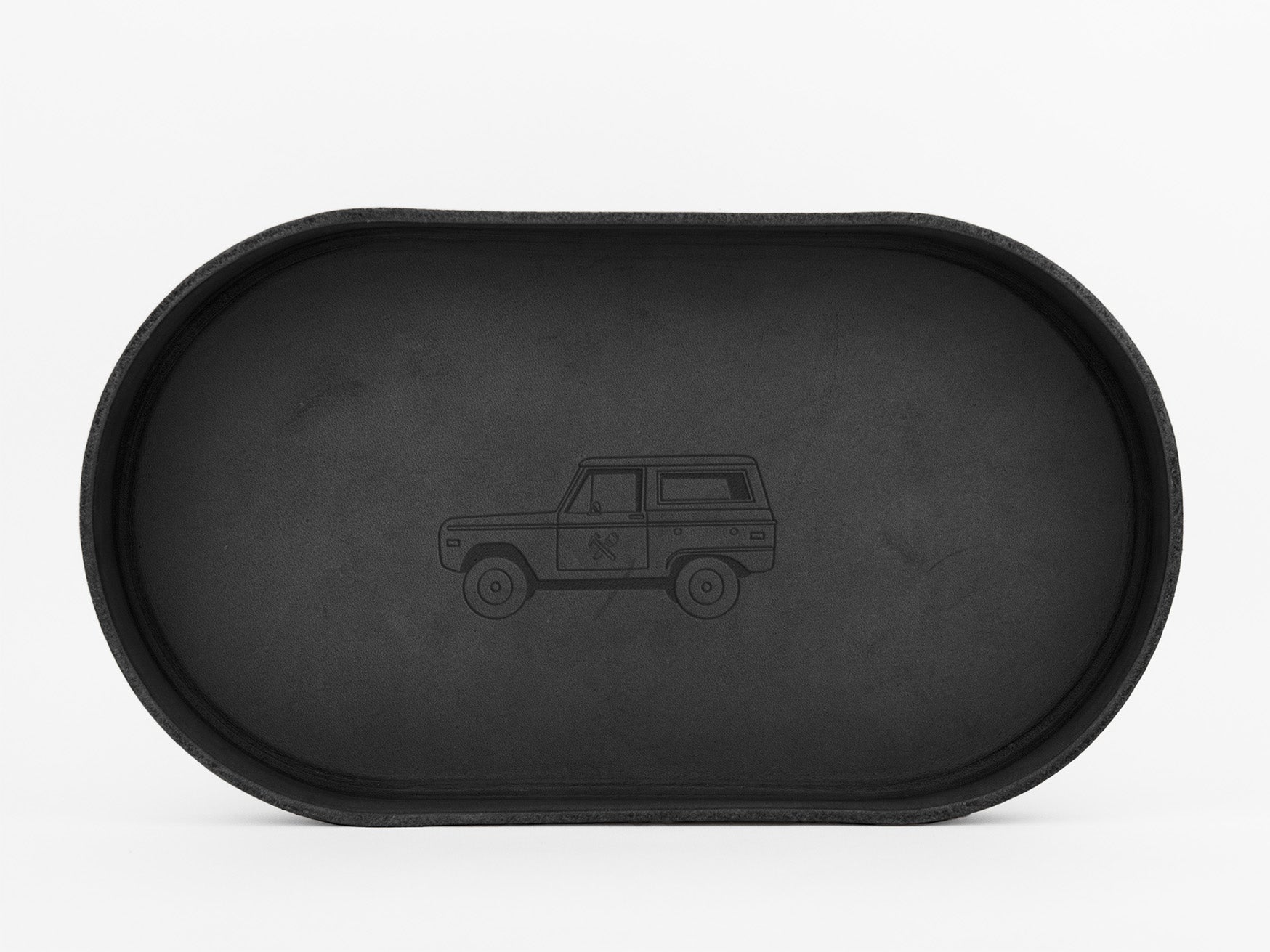 	
A black, oval-shaped tray with a simple outline illustration of a vintage SUV engraved in the center, set against a plain white background.