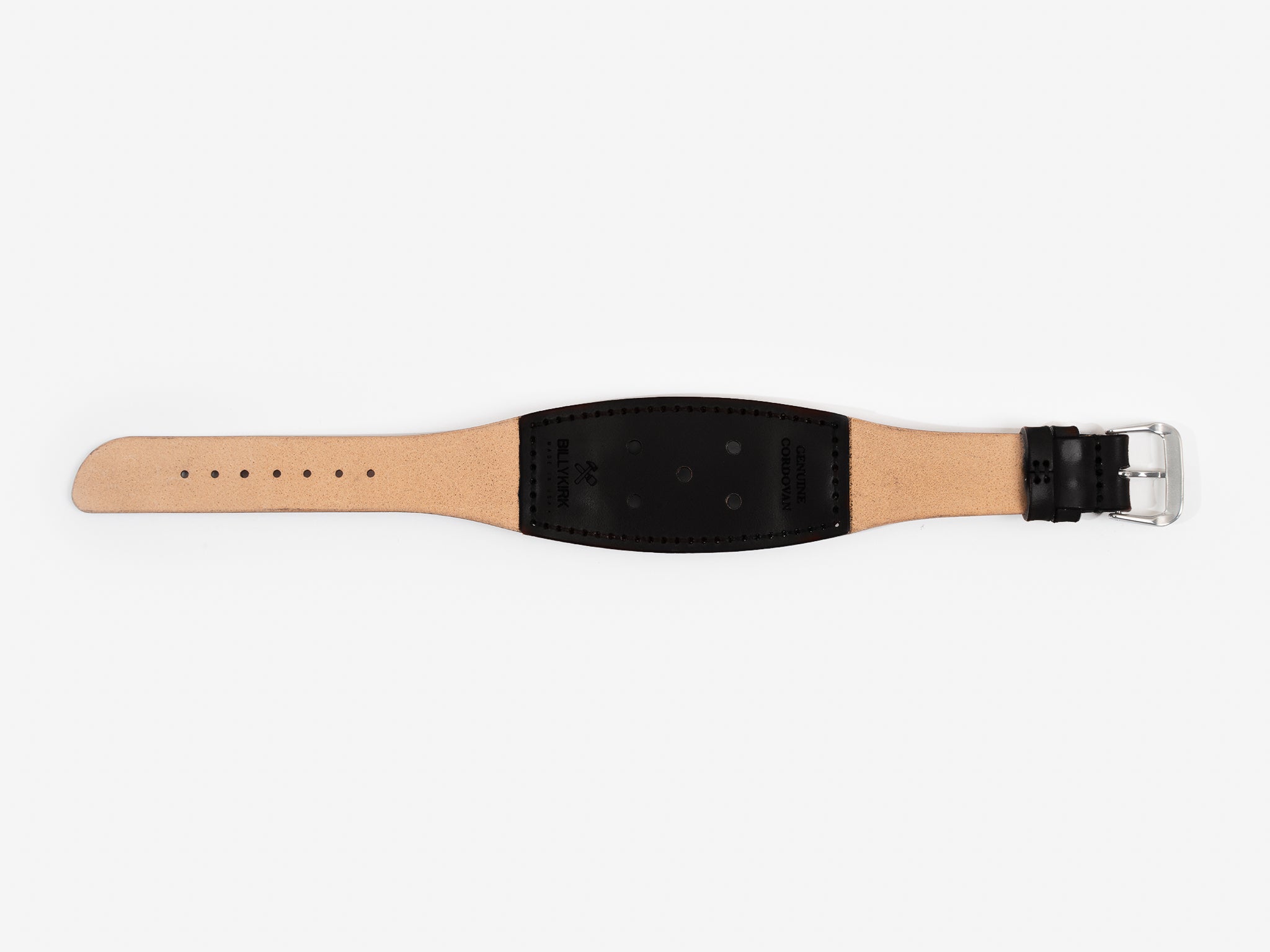 A wide, black and natural cordovan leather watch strap with black stitching, adjustment holes, a silver buckle, and the brand name BILLYKIRK embossed on it.