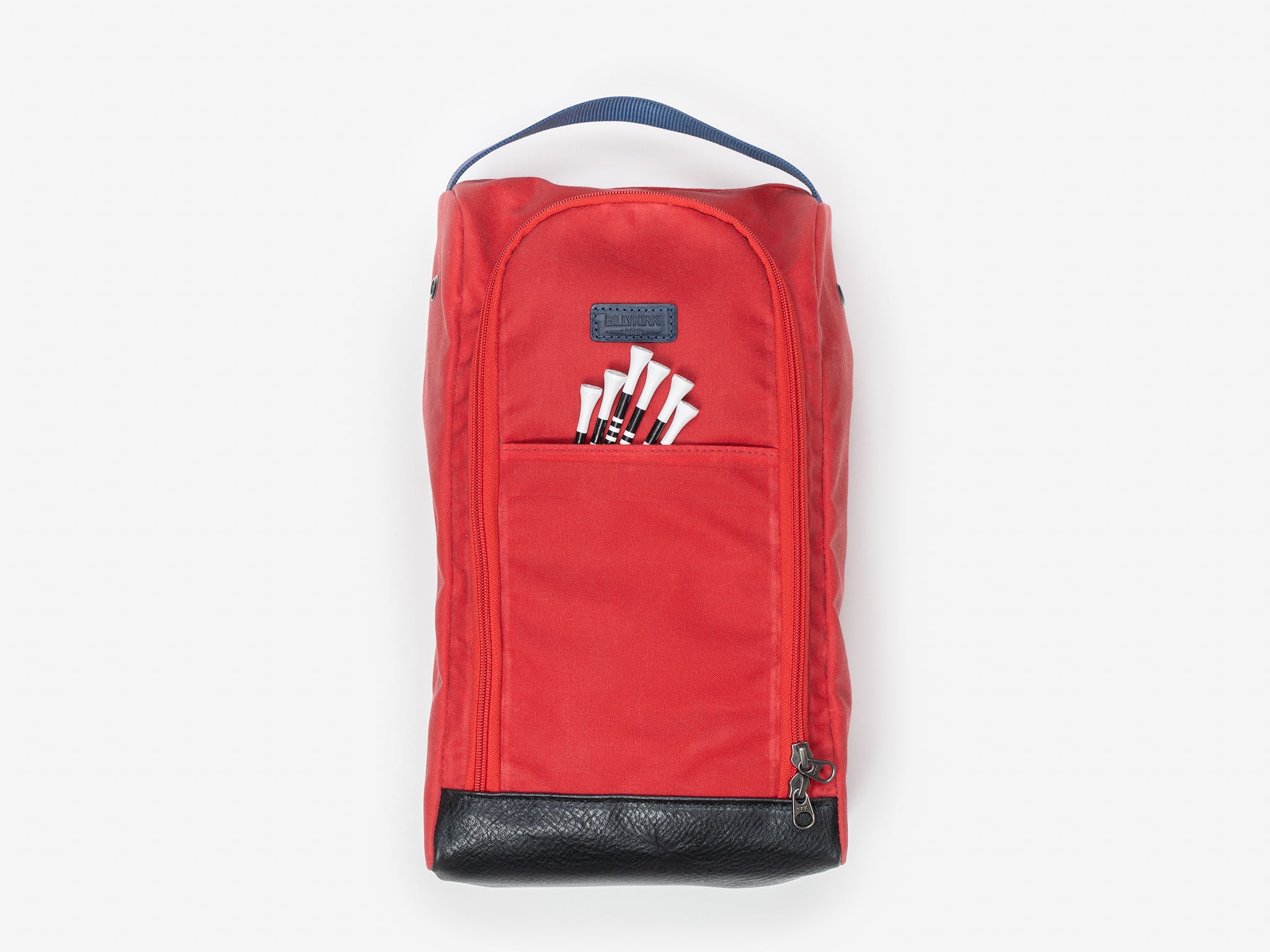 A red fabric shoe bag with a black handle on top, a front zipper pocket, a front flap with six white tees, and a black base, displayed against a plain light background.