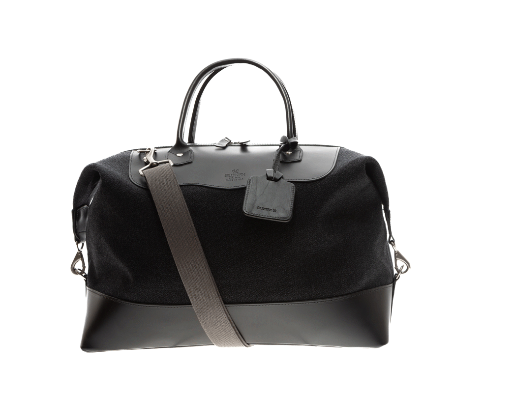 Video of black carryall spinning around showing all sides of the bag on an off-white background
