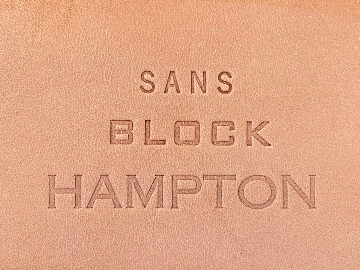 Embossed text on light brown leather reads: SANS in small letters, BLOCK in medium-sized block letters, and HAMPTON in large capital letters.