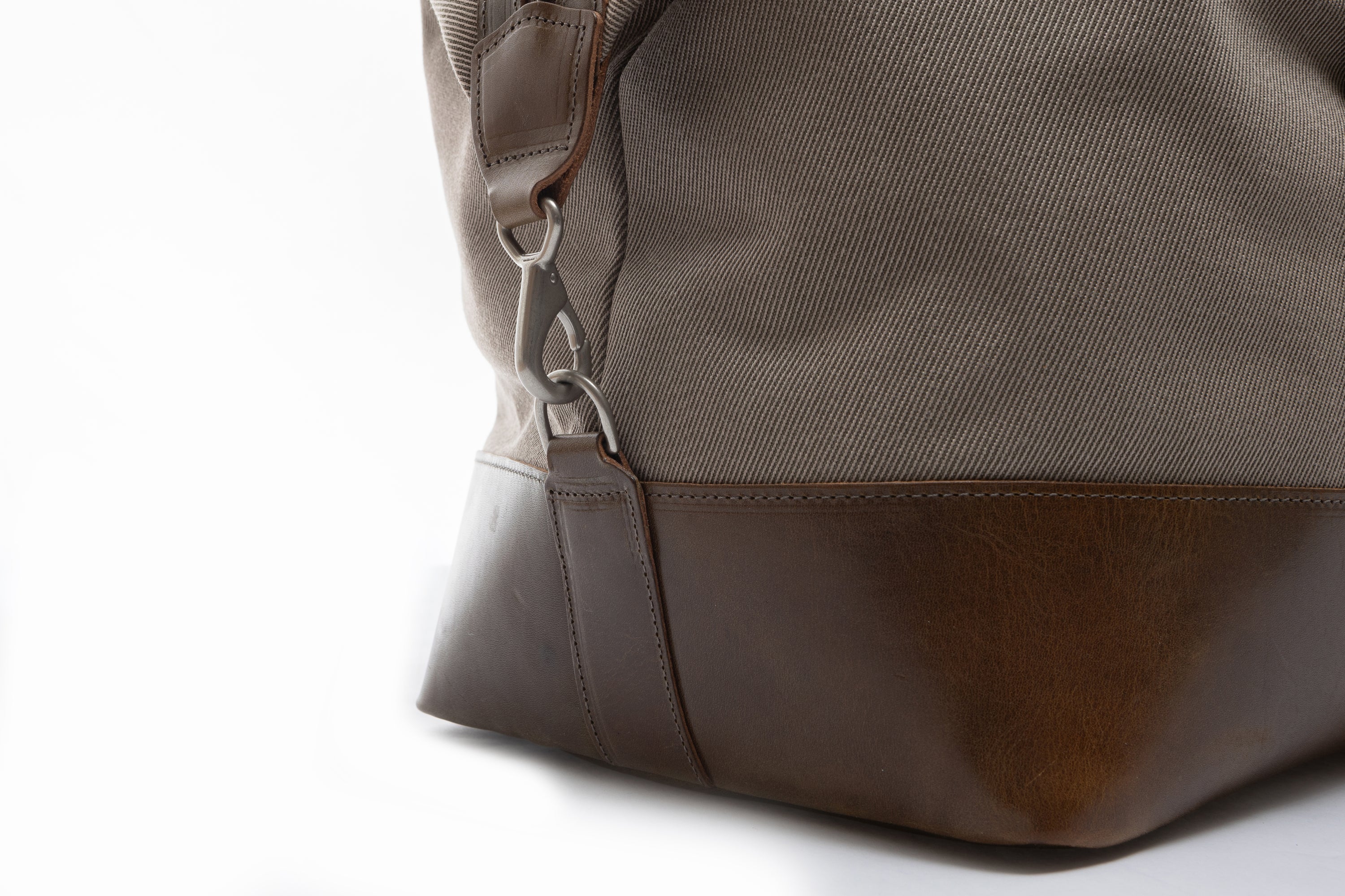 Close-up of a olive leather bag with a white background