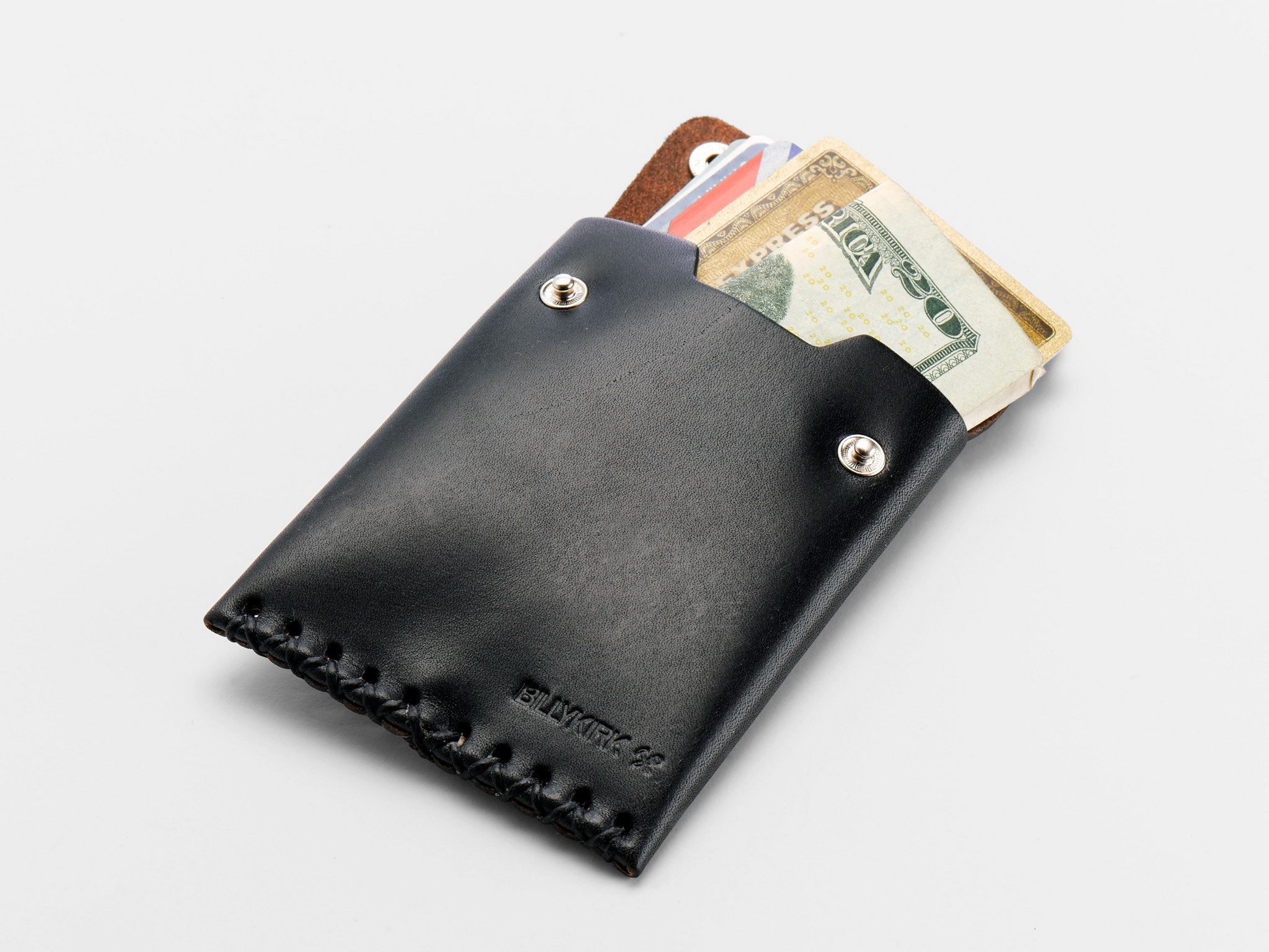 A black leather wallet partially open, revealing U.S. dollar bills and several credit cards inside, against a plain white background.