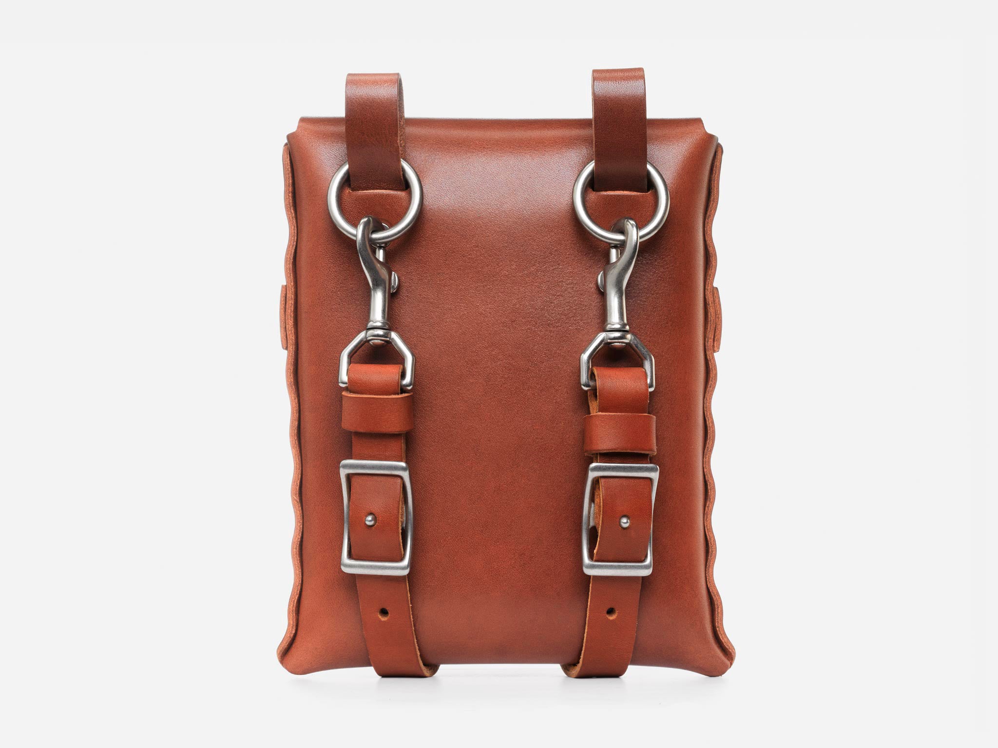 A brown leather satchel with silver buckles, rings, and clasps on the front, photographed against a plain white background.