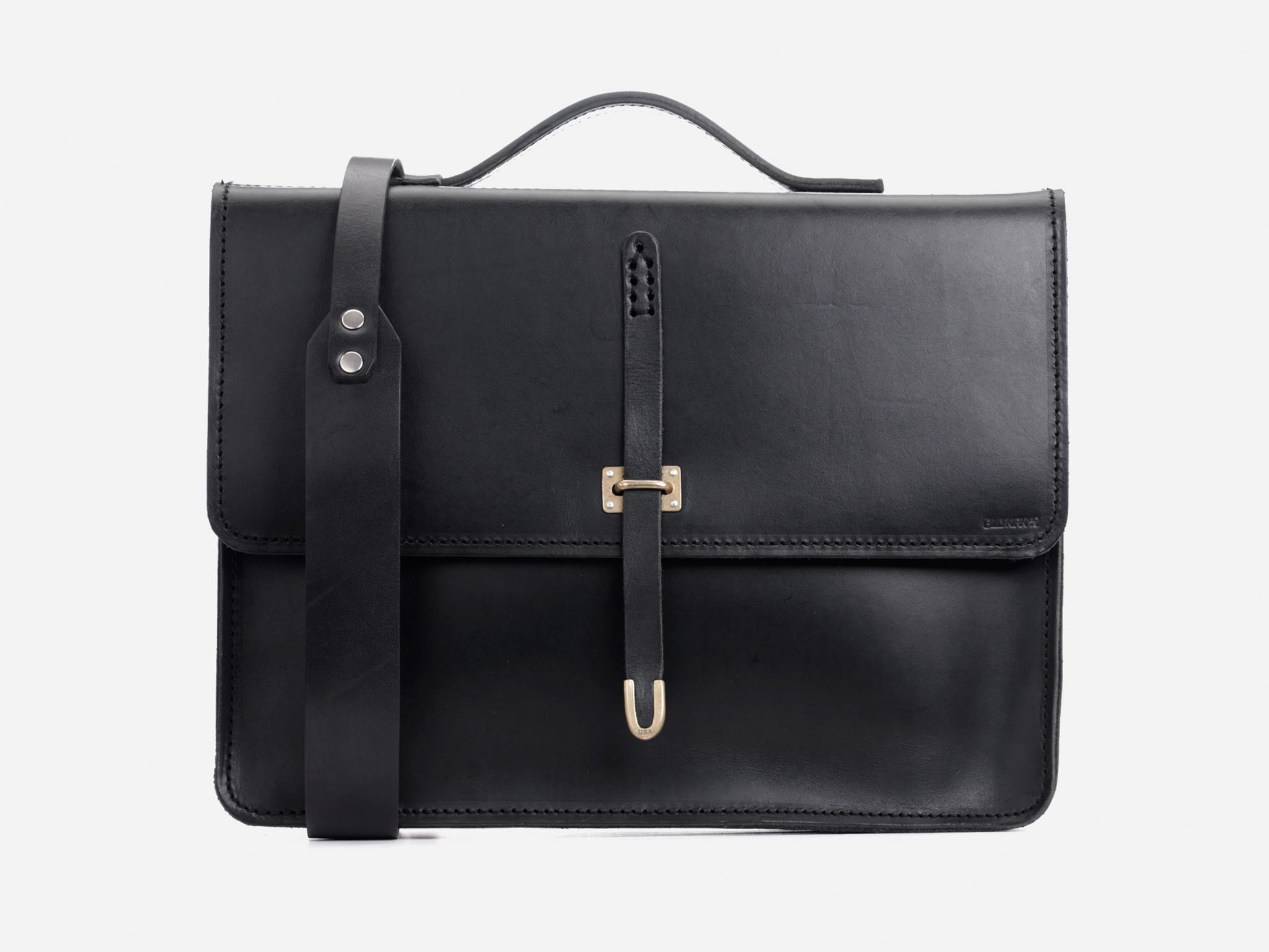 A sleek black leather satchel with a top handle, a front flap secured by a strap and metal buckle, and an adjustable shoulder strap, displayed against a plain white background.