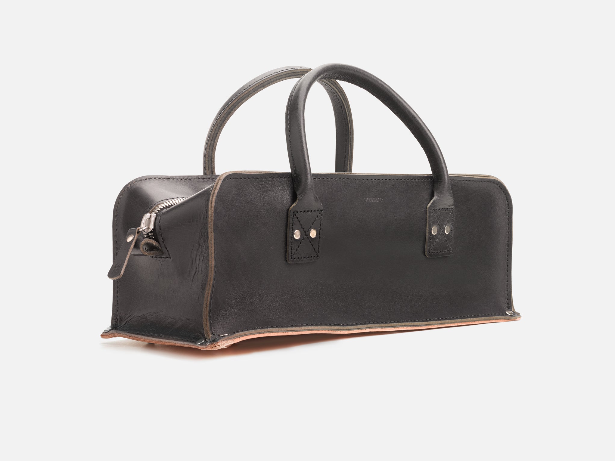 A 3/4 view of a black leather tool bag with rivet reinforced corners set in a white background