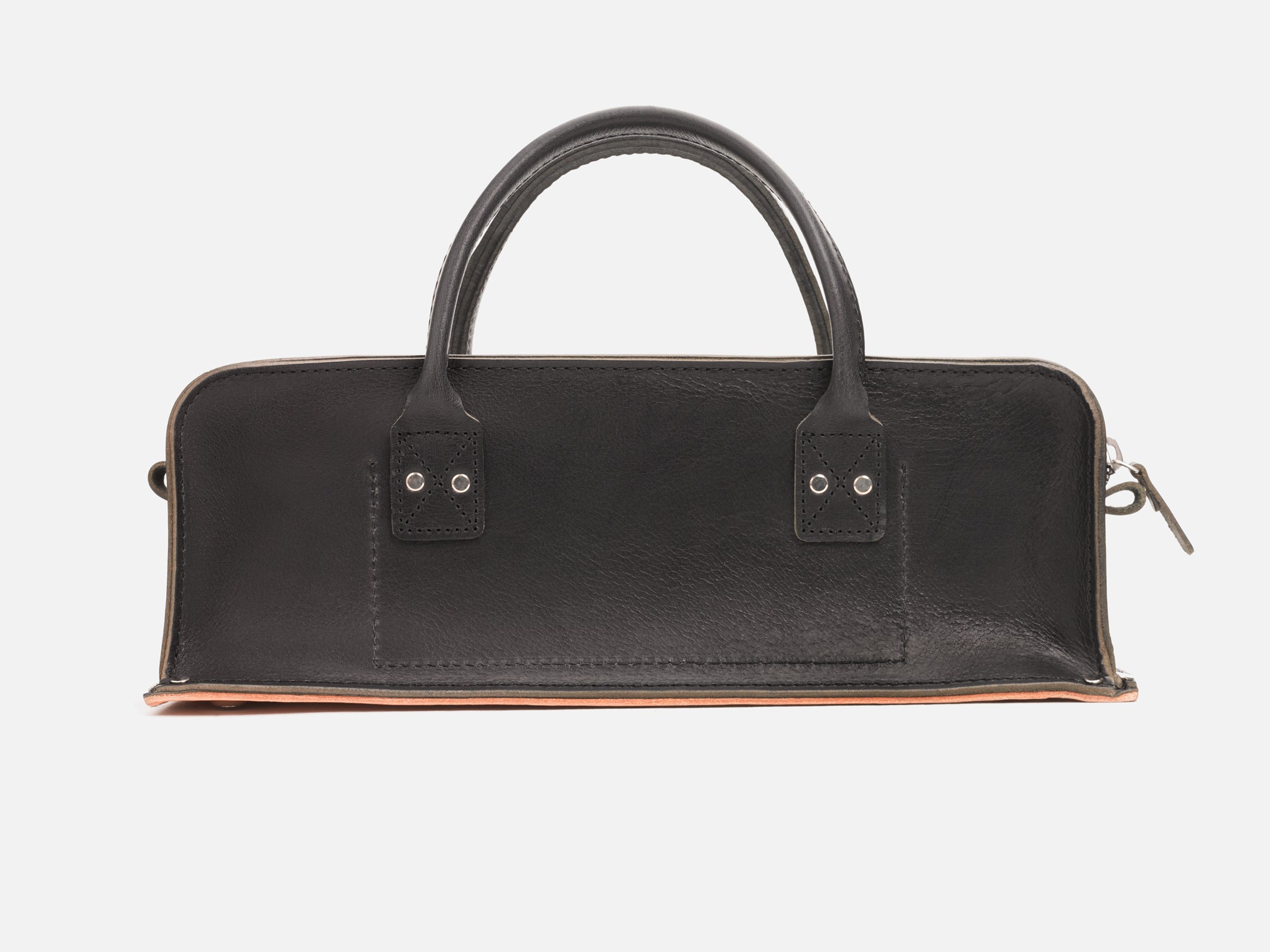 A back view of a black leather tool bag with rivet reinforced corners and handles set in a white background