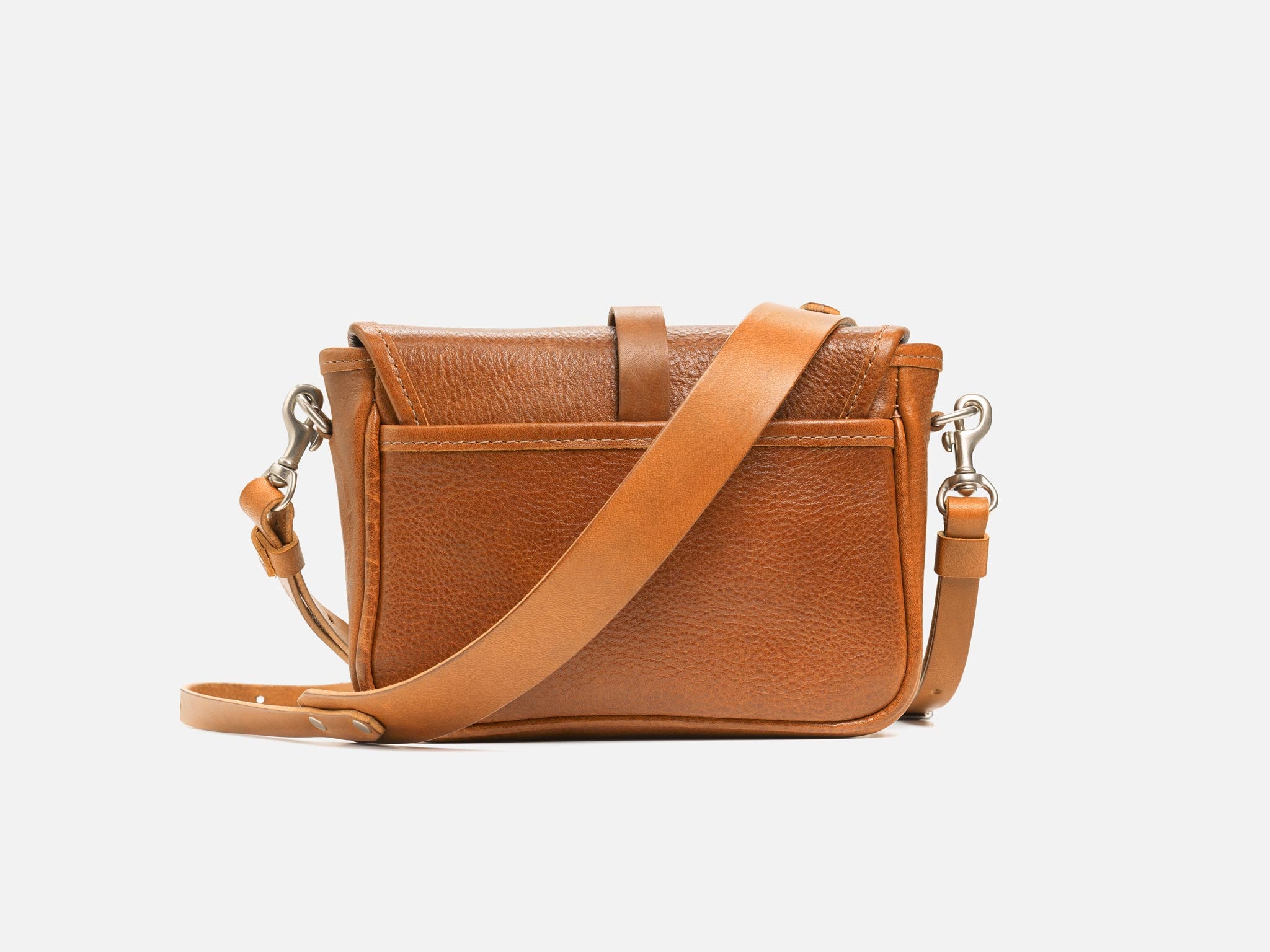 A small brown leather crossbody bag with a front pocket, silver hardware, and an adjustable strap, displayed against a plain white background.