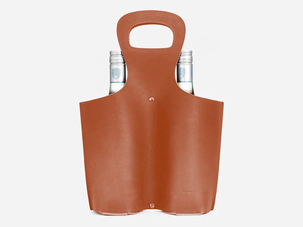 A tan leather wine carrier with two glass bottles inside, featuring a single handle cutout at the top for easy carrying.