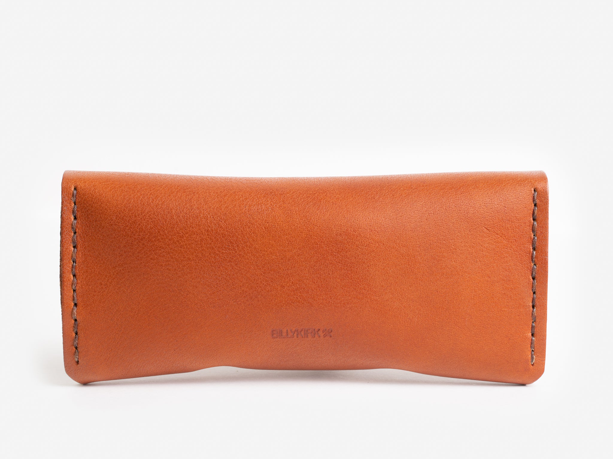 A brown leather eyeglass case with visible stitching along the sides, displayed against a white background. The brand name is embossed in the center of the case.