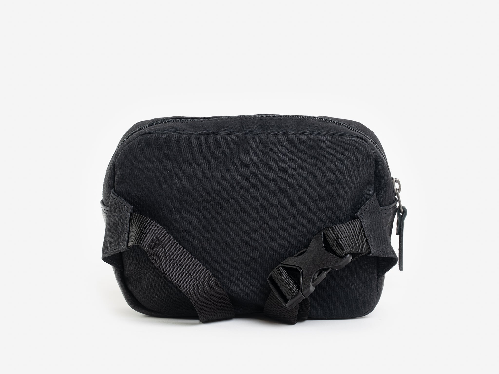 Back view of a small black waxed canvas crossbody bag with adjustable strap.