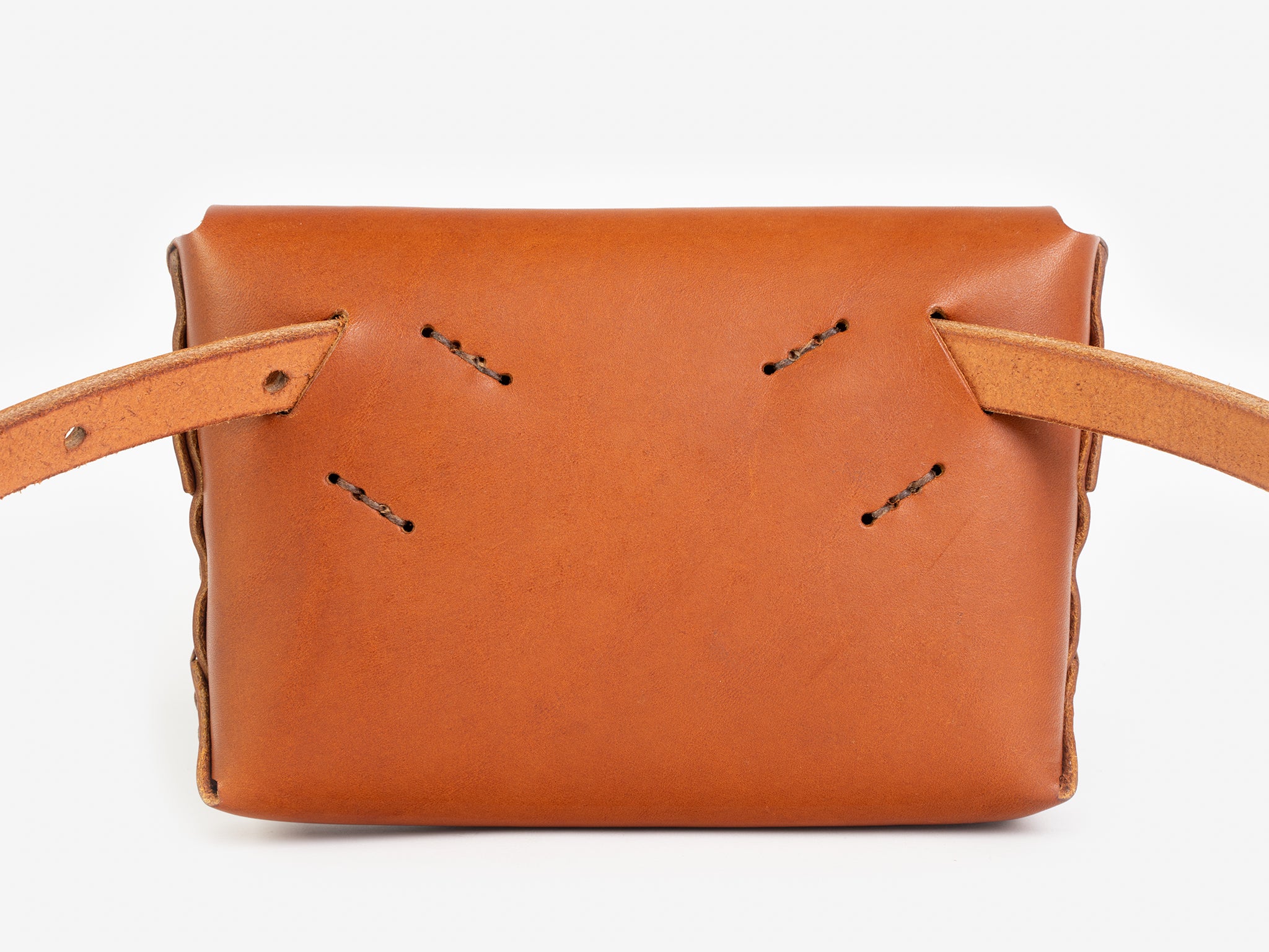 Back view of a tan leather belt crossbody bag with a smooth finish, featuring  hand-stitching details, displayed against a white background.
