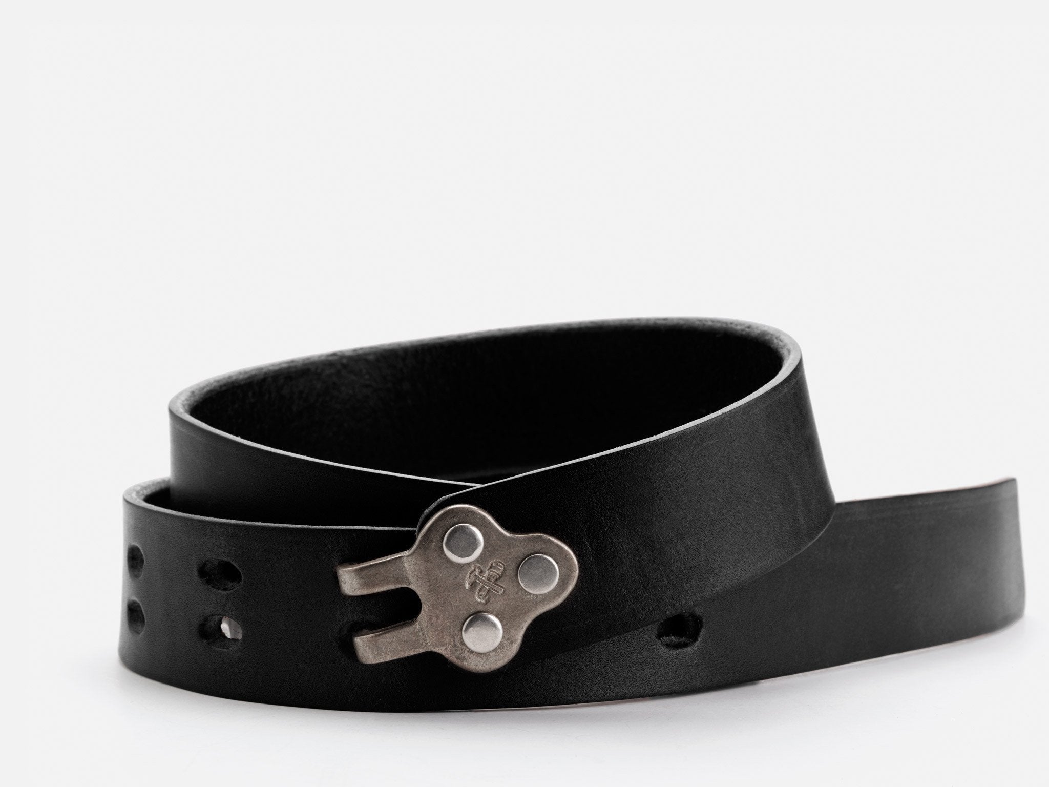 A black leather belt with a unique metallic buckle resembling a vintage key, coiled neatly on a white background.